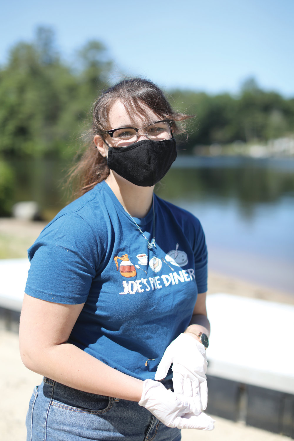 Even with a mask, campers will see new lifeguard Erin McKeen smiling at her new post on Echo Lake. At far right, camp counselors like Christina Rondeau work diligently to follow cleaning practices to prepare for the campers’ arrival.